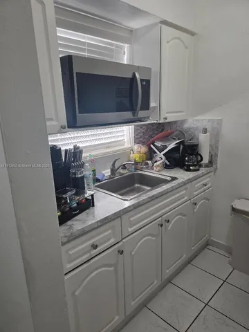 a kitchen with appliances a sink and cabinets