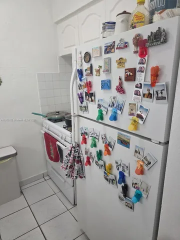 a utility room with fridge and wall