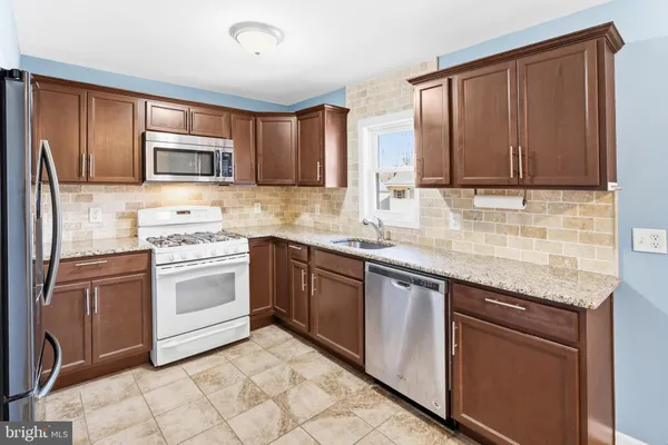 a kitchen with granite countertop cabinets stainless steel appliances and a sink