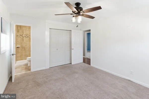 an empty room with fan and entrance