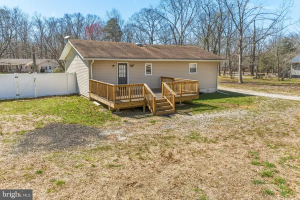 a view of a house with backyard and trees