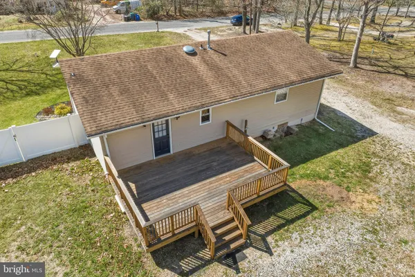 a view of a roof deck with couches and wooden fence