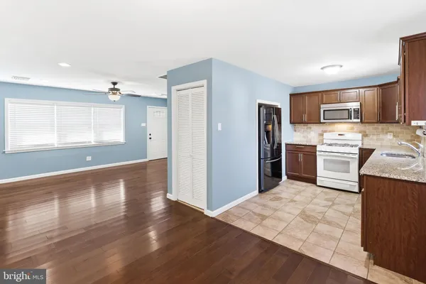 a kitchen with stainless steel appliances granite countertop a refrigerator stove top oven and sink