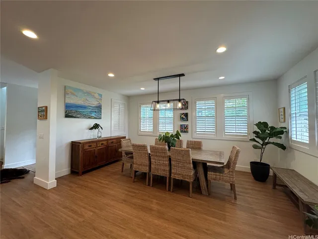 a living room with furniture a large window and wooden floor