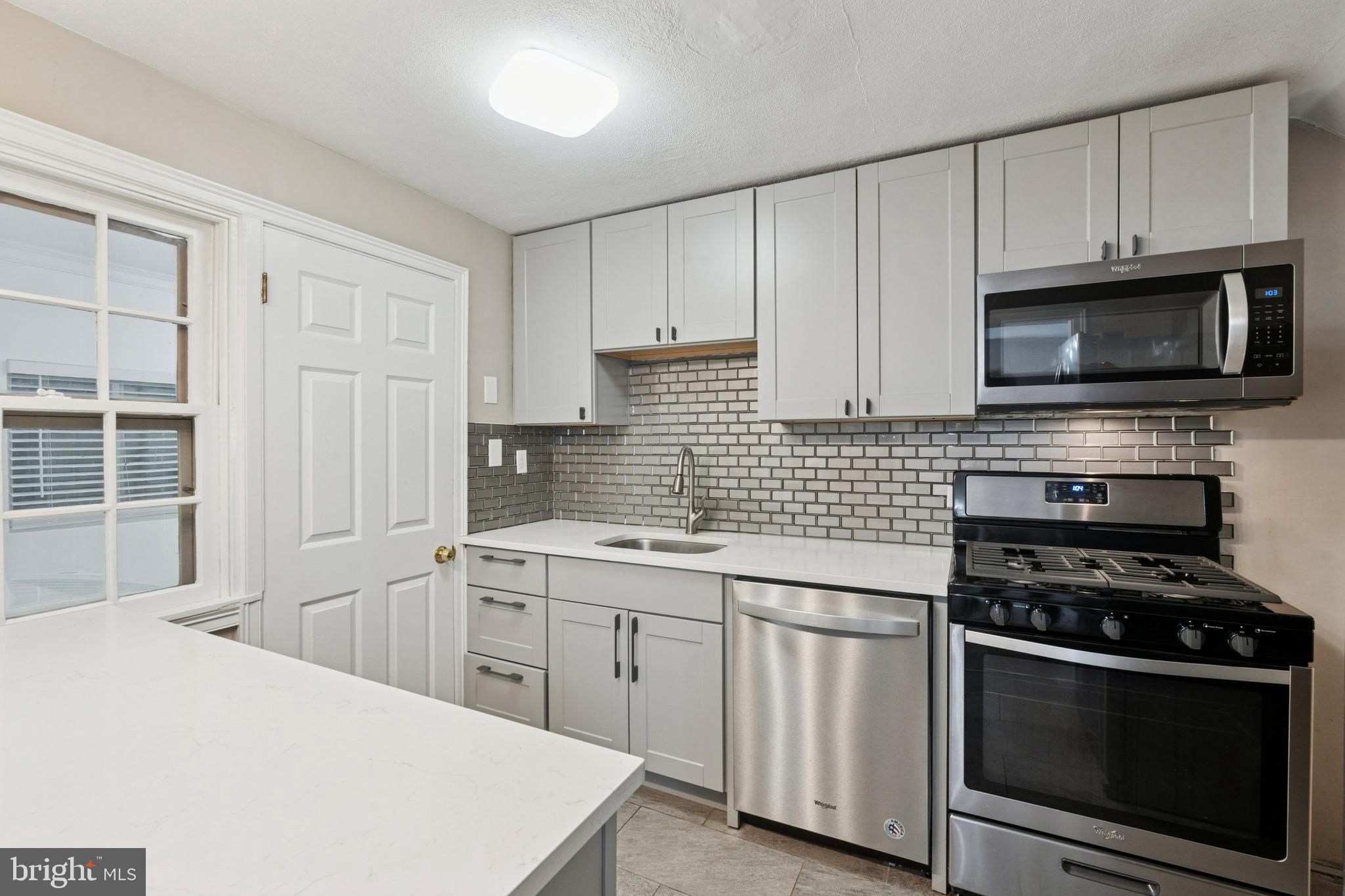 614 Wises Mill Road Philadelphia, PA 19128 - Photo 11 of 42 a kitchen with white cabinets and stainless steel appliances