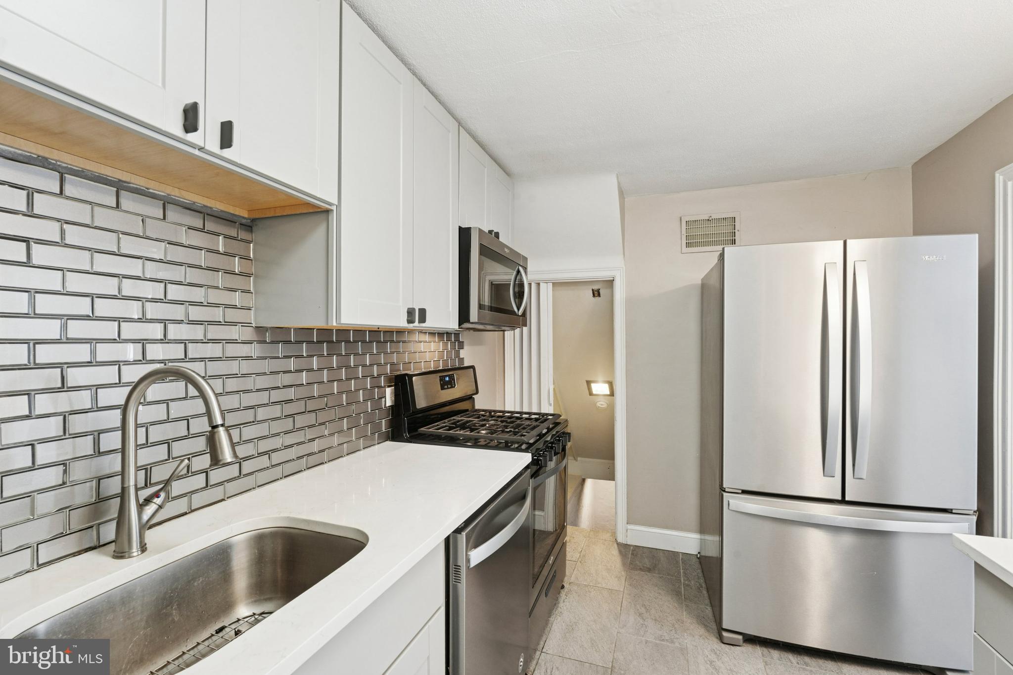 614 Wises Mill Road Philadelphia, PA 19128 - Photo 9 of 42 a kitchen with a refrigerator sink and stove