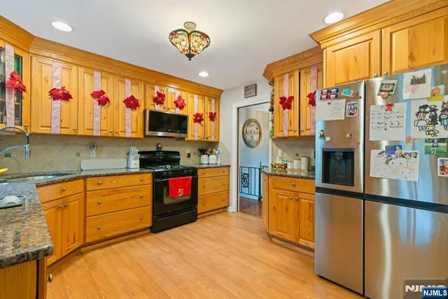 a kitchen with stainless steel appliances granite countertop a refrigerator and a stove top oven