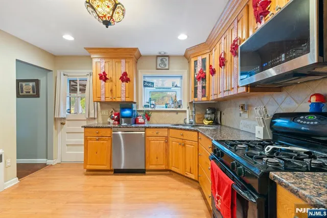 a kitchen with stainless steel appliances granite countertop a stove and a sink