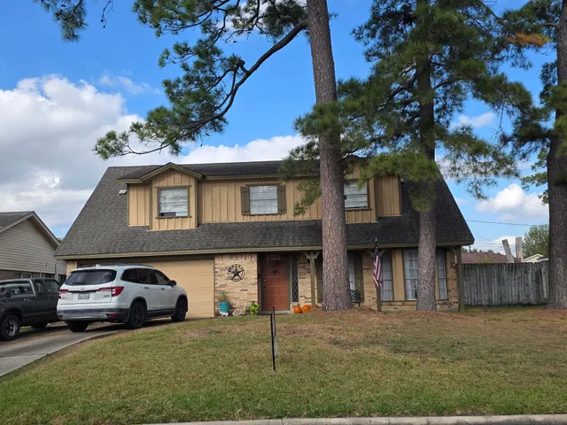 a front view of a house with a garden and parking