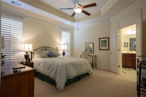 a spacious bedroom with a bed and a chandelier