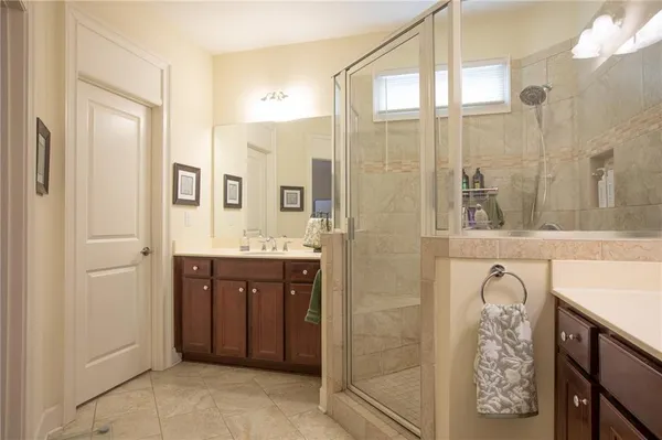 a spacious bathroom with a granite countertop sink a mirror and a shower