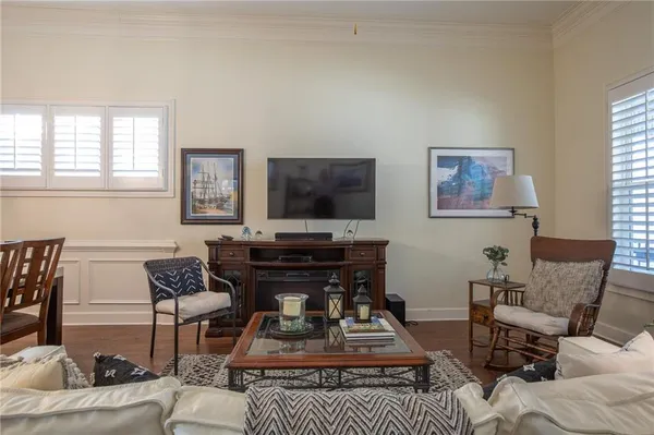 a living room with furniture a flat screen tv and a window