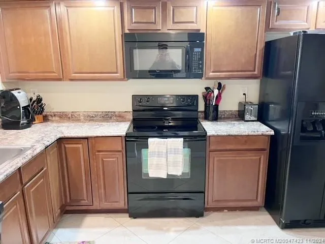 a kitchen with granite countertop a refrigerator stove and microwave