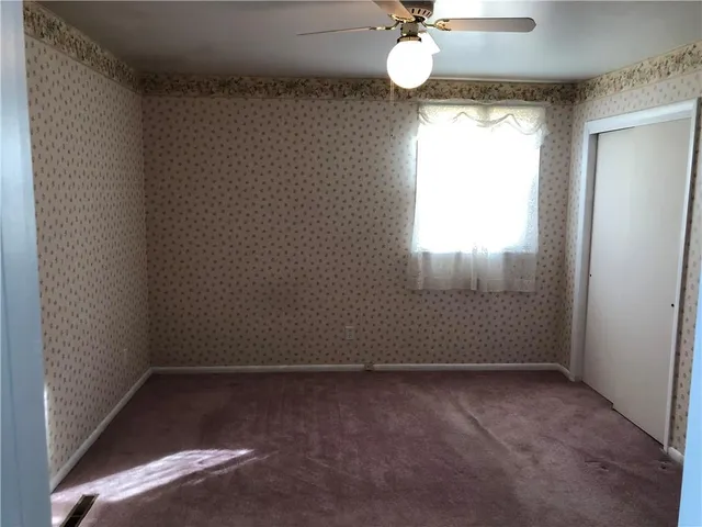 a white toilet sitting next to a small window