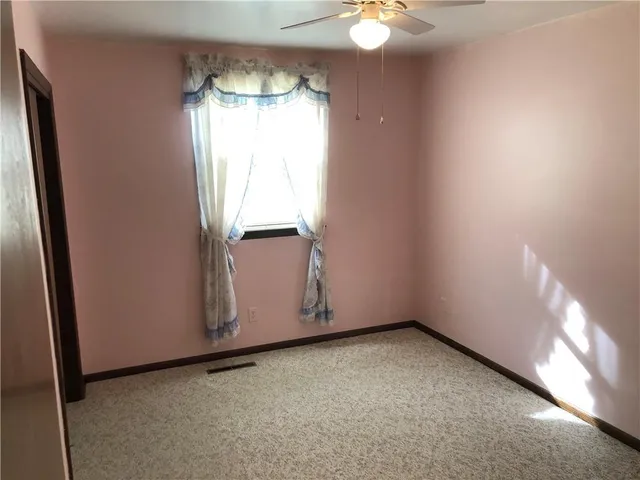 a view of a hallway with wooden floor and stairs