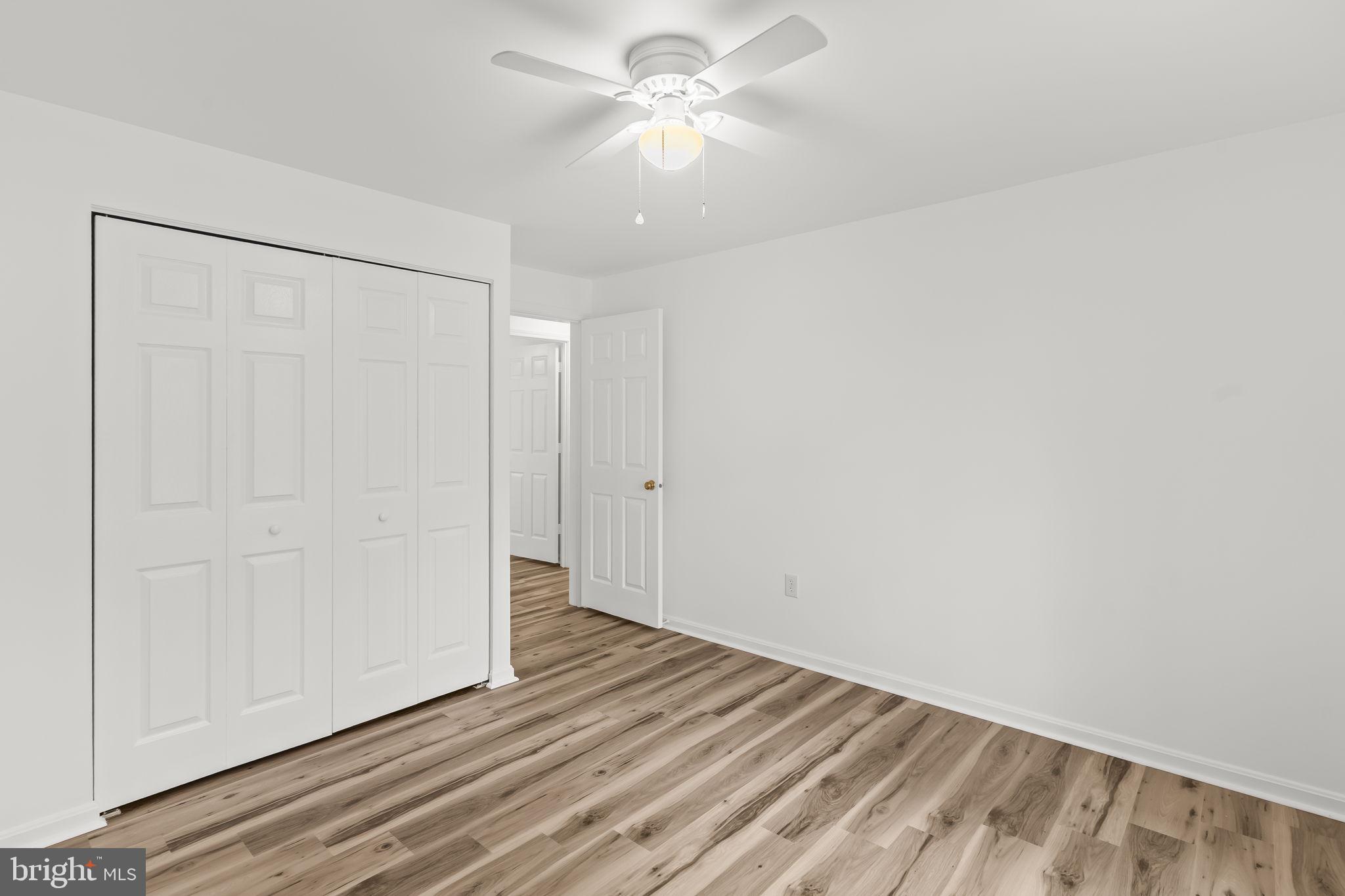 11223 Rawhide Road Lusby, MD 20657 - Photo 11 of 33 a view of a room with wooden floor and a ceiling fan