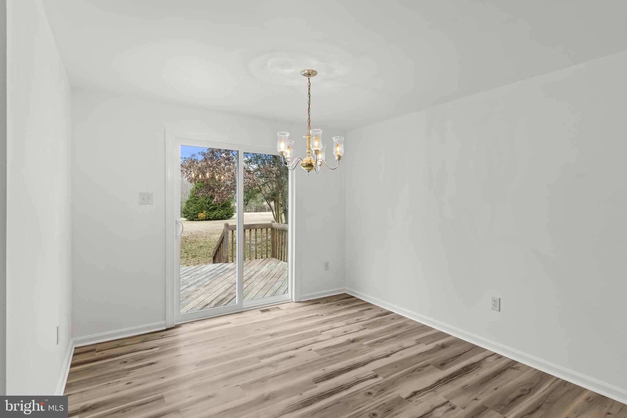 11223 Rawhide Road Lusby, MD 20657 - Photo 5 of 33 a view of a room with wooden floor ceiling fan and window