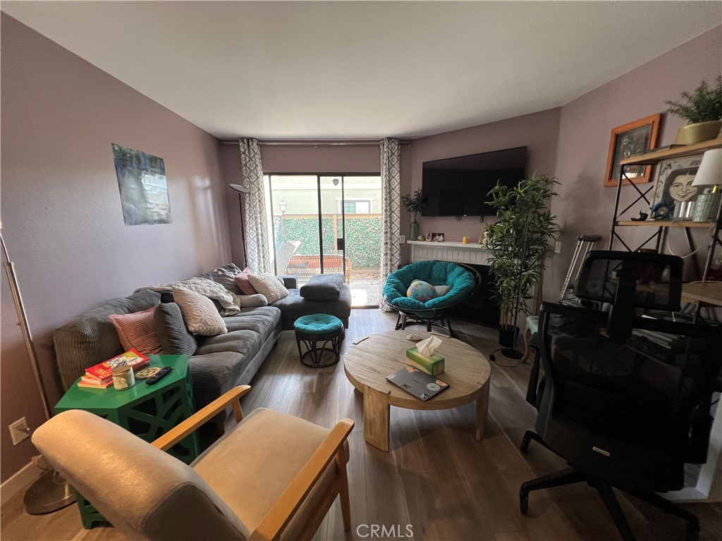 1111 Packers Circle, Unit 25 Tustin, CA 92780 - Photo 4 of 10 a living room with furniture a flat screen tv and a floor to ceiling window