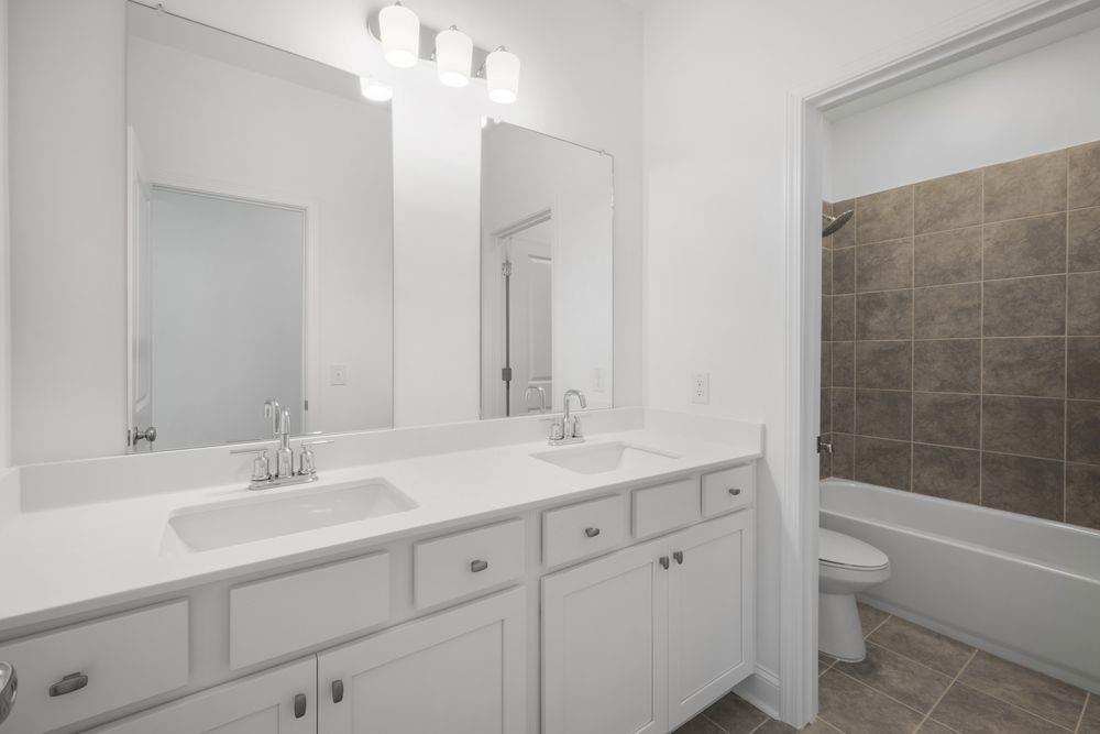 8925 Avonbrook Cl Ball Ground, GA 30107 - Photo 27 of 48 a bathroom with a granite countertop sink a toilet and bathtub