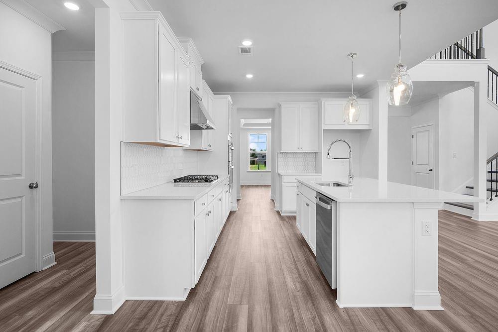 8925 Avonbrook Cl Ball Ground, GA 30107 - Photo 8 of 48 a kitchen with kitchen island a white counter top space a sink and cabinets