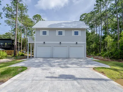 a front view of a house with a garden and yard