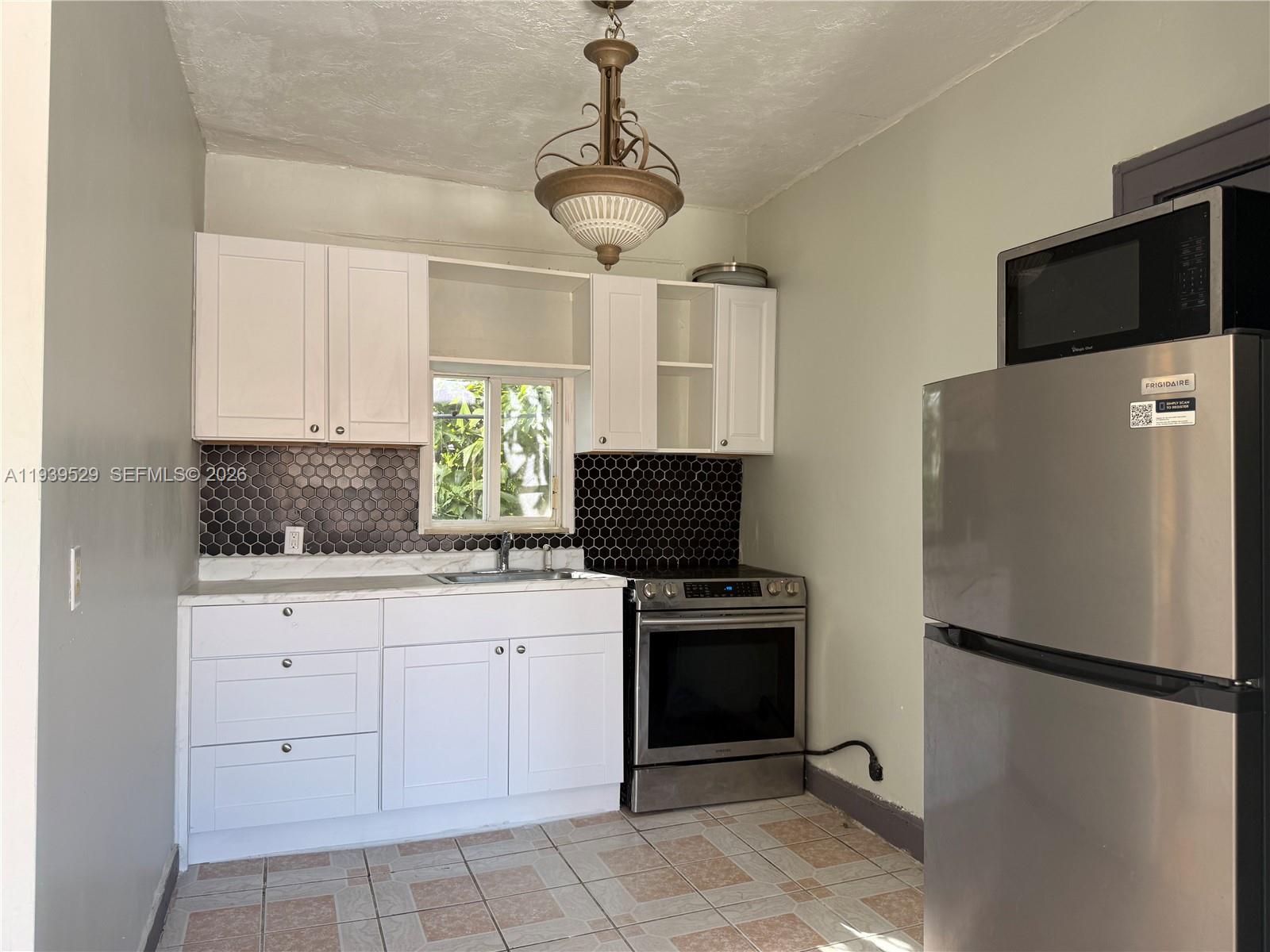 22 Northeast 51st Street, Unit 2 Miami, FL 33137 - Photo 8 of 14 a kitchen with a stainless steel appliances a refrigerator and a stove top oven