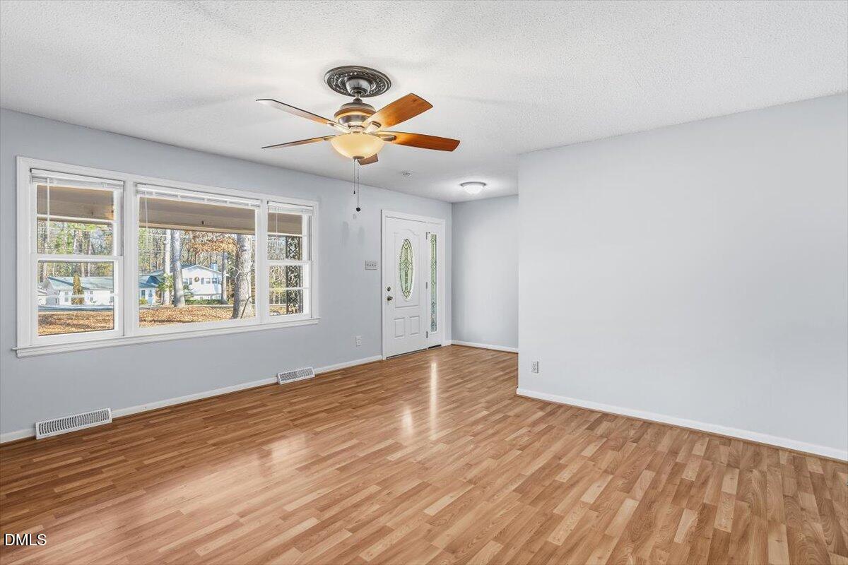 511 Hunter Street Durham, NC 27712 - Photo 5 of 31 a view of an empty room with window and wooden floor