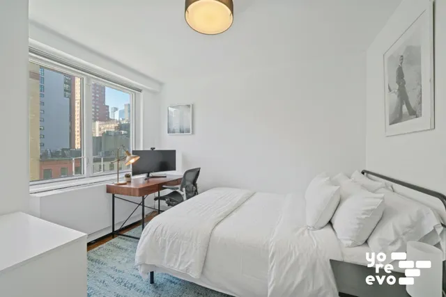 a bedroom with a large bed and a chandelier