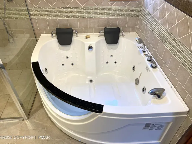 a bathroom with a bathtub and mirror