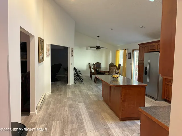 a view of kitchen with refrigerator stove and wooden floor