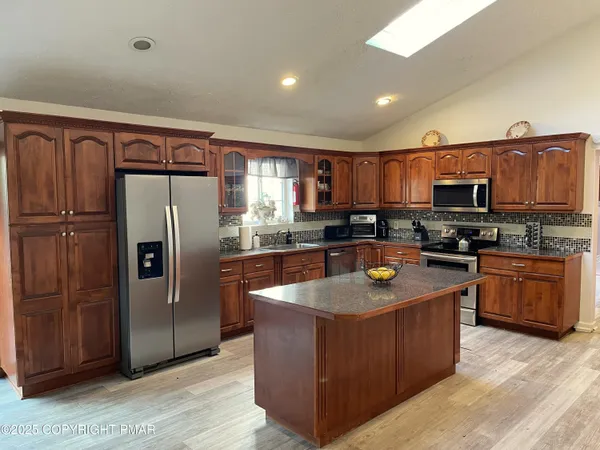 a kitchen with stainless steel appliances granite countertop a refrigerator a stove a sink a washer and dishwasher