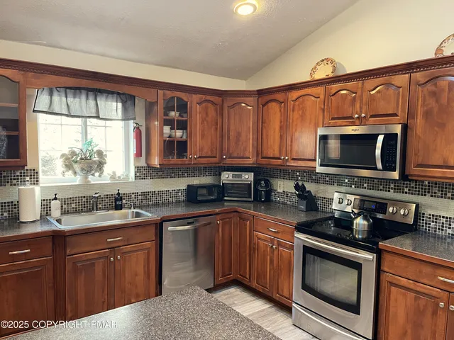 a kitchen with stainless steel appliances granite countertop a sink stove and microwave
