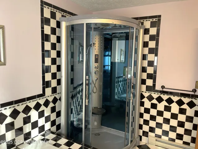 a bathroom with a shower and a glass door