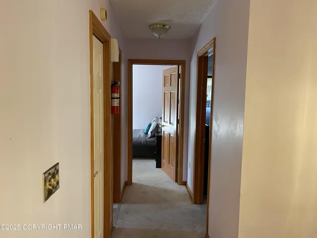 a view of a hallway with a livingroom and a bathroom with a sink