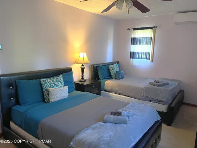 a bedroom with two beds and a window