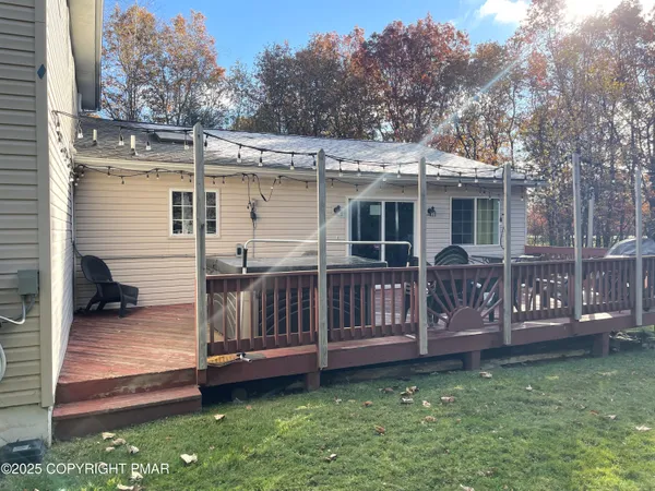 a view of a house with a wooden deck and a yard