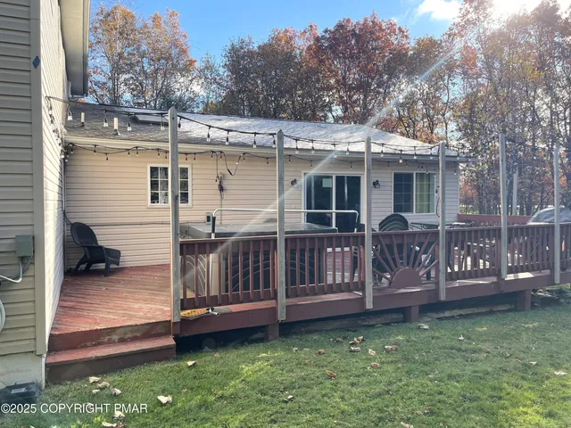 a view of a house with a wooden deck and a yard