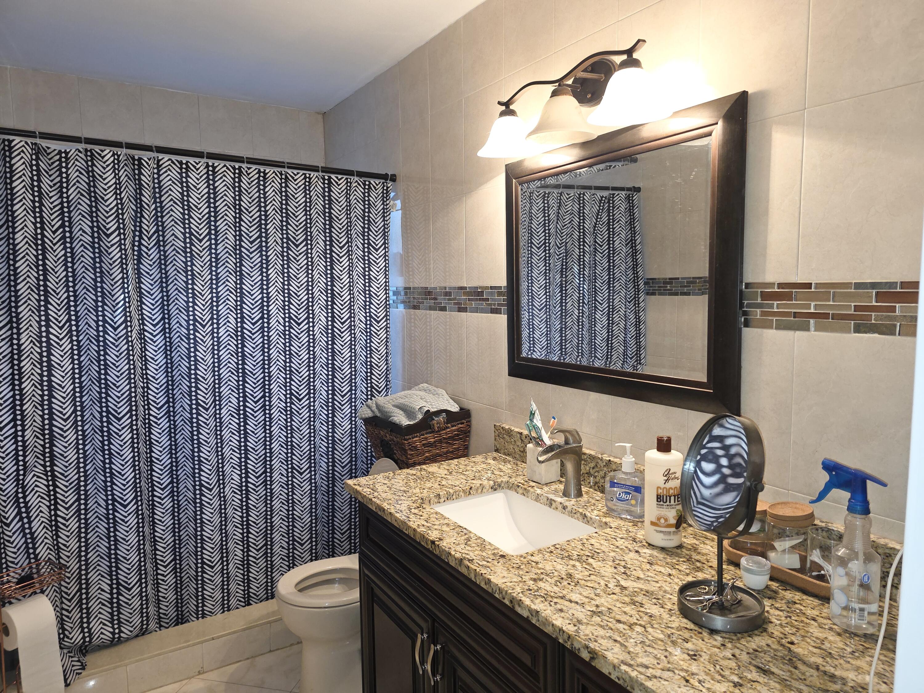 4118 Ruth Road Lake Worth, FL 33461 - Photo 17 of 21 a bathroom with a granite countertop sink and a mirror