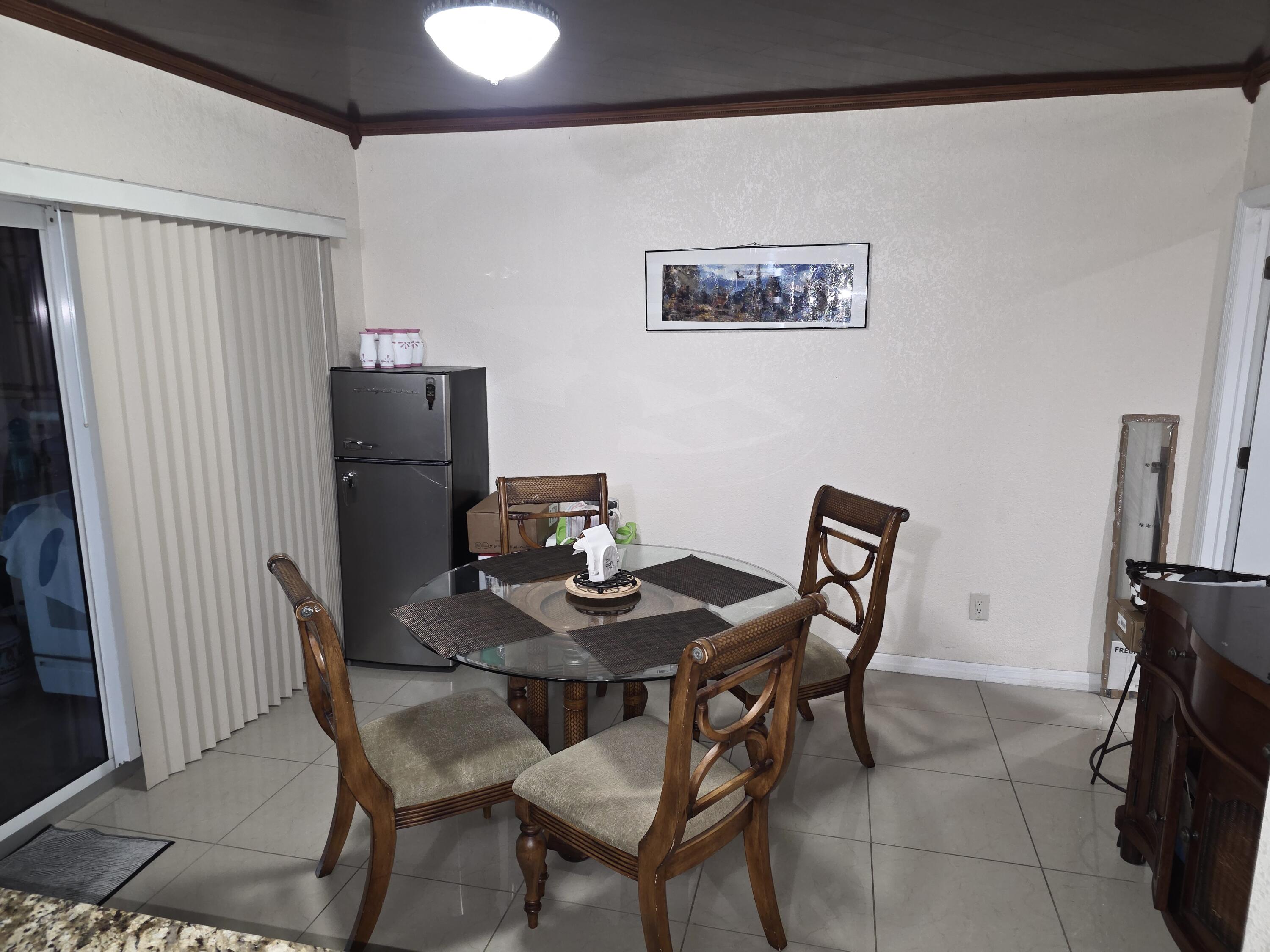 4118 Ruth Road Lake Worth, FL 33461 - Photo 18 of 21 a dining room with furniture and a refrigerator
