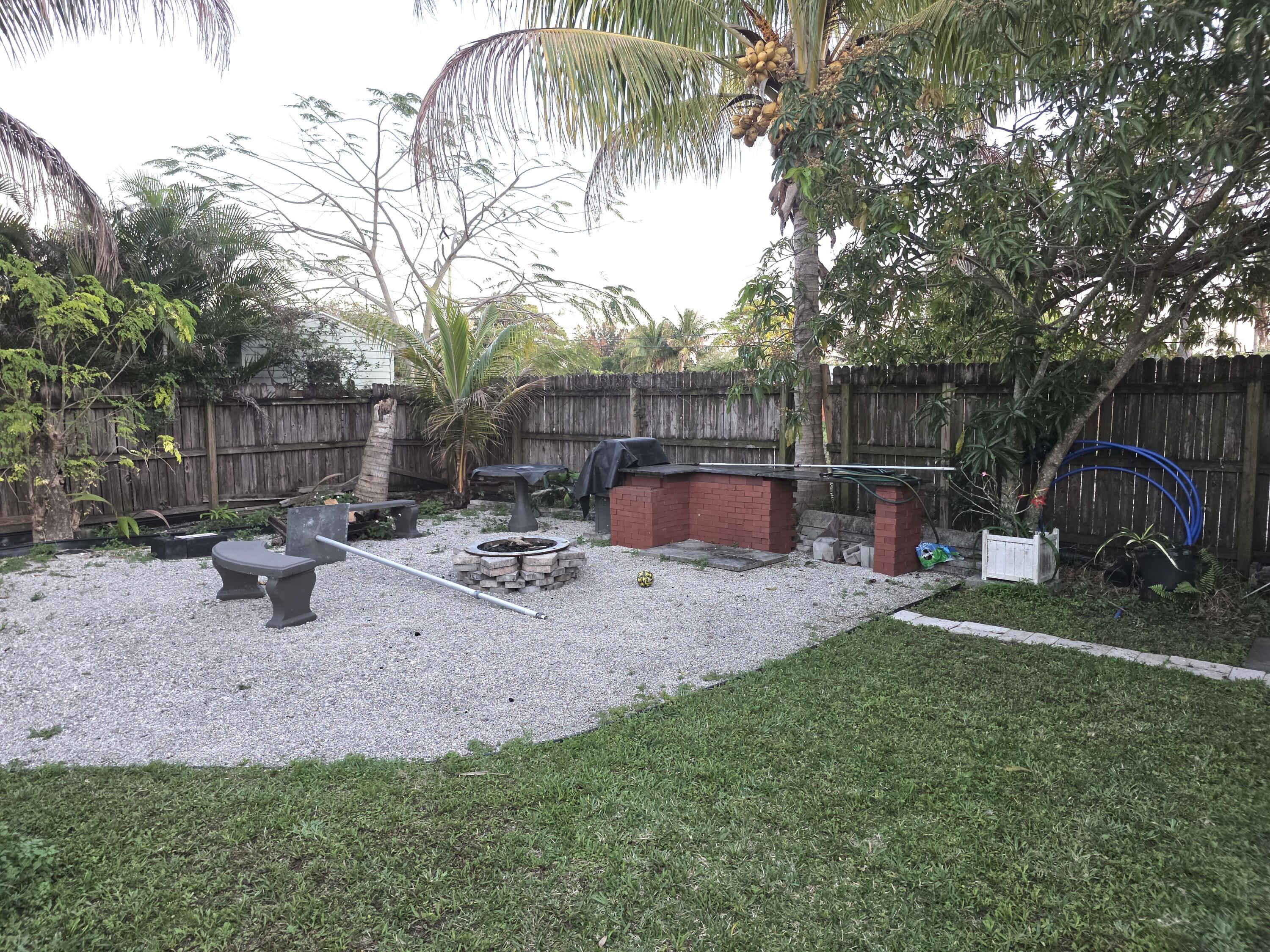 4118 Ruth Road Lake Worth, FL 33461 - Photo 8 of 21 a view of a backyard with furniture and a fire pit