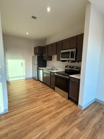 a large kitchen with stainless steel appliances granite countertop a stove and a sink