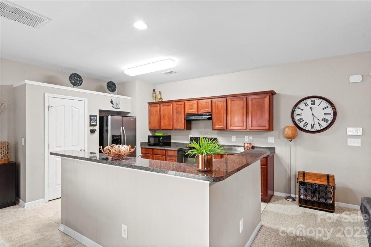 13004 Rothe House Road Charlotte, NC 28273 - Photo 11 of 27 a room with stainless steel appliances a clock on the wall and a refrigerator