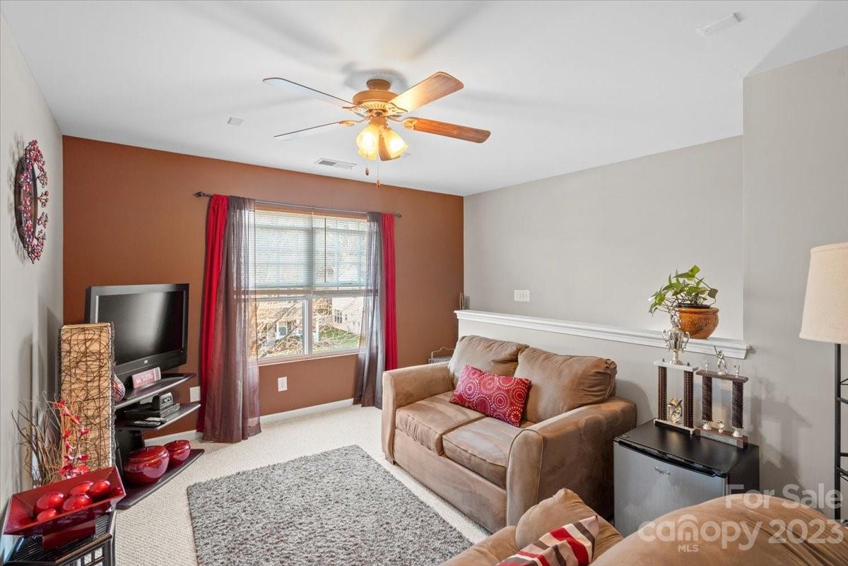 13004 Rothe House Road Charlotte, NC 28273 - Photo 17 of 27 a living room with furniture a flat screen tv and a window