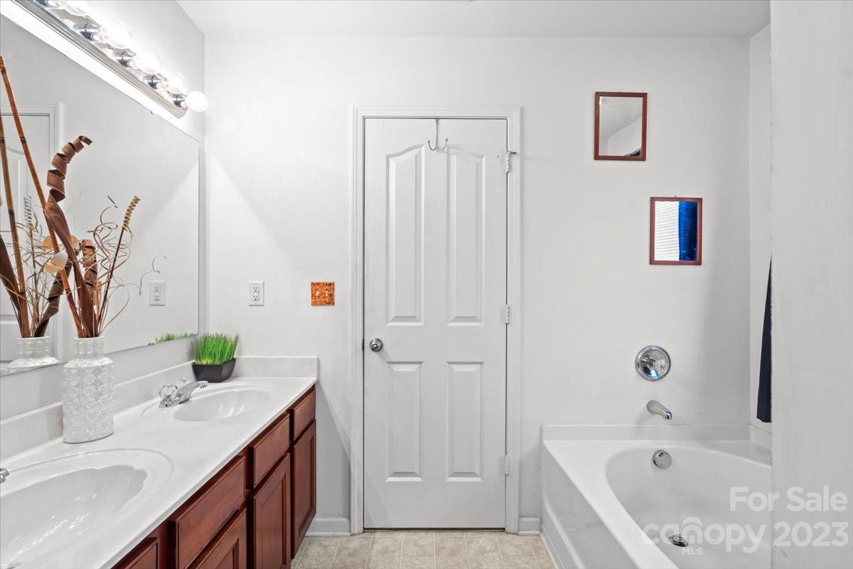 13004 Rothe House Road Charlotte, NC 28273 - Photo 25 of 27 a bathroom with a tub sink and mirror