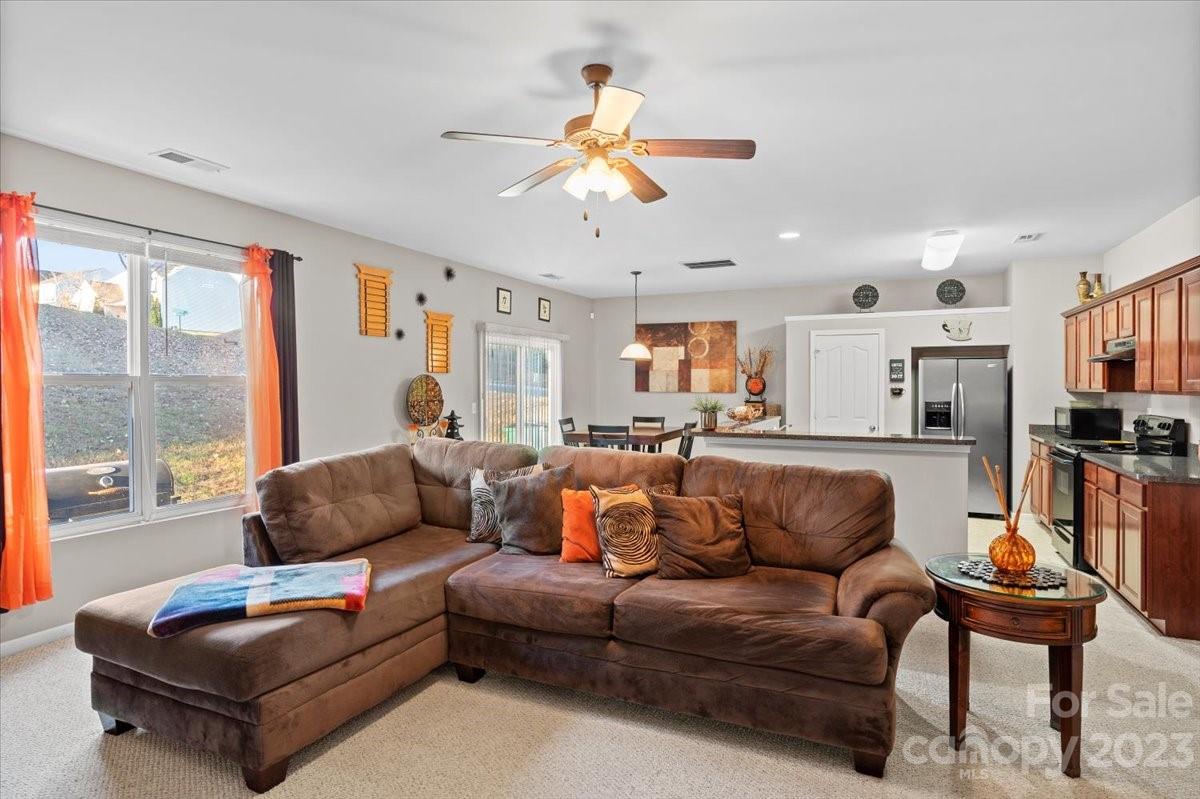 13004 Rothe House Road Charlotte, NC 28273 - Photo 7 of 27 a living room with furniture a ceiling fan and a window