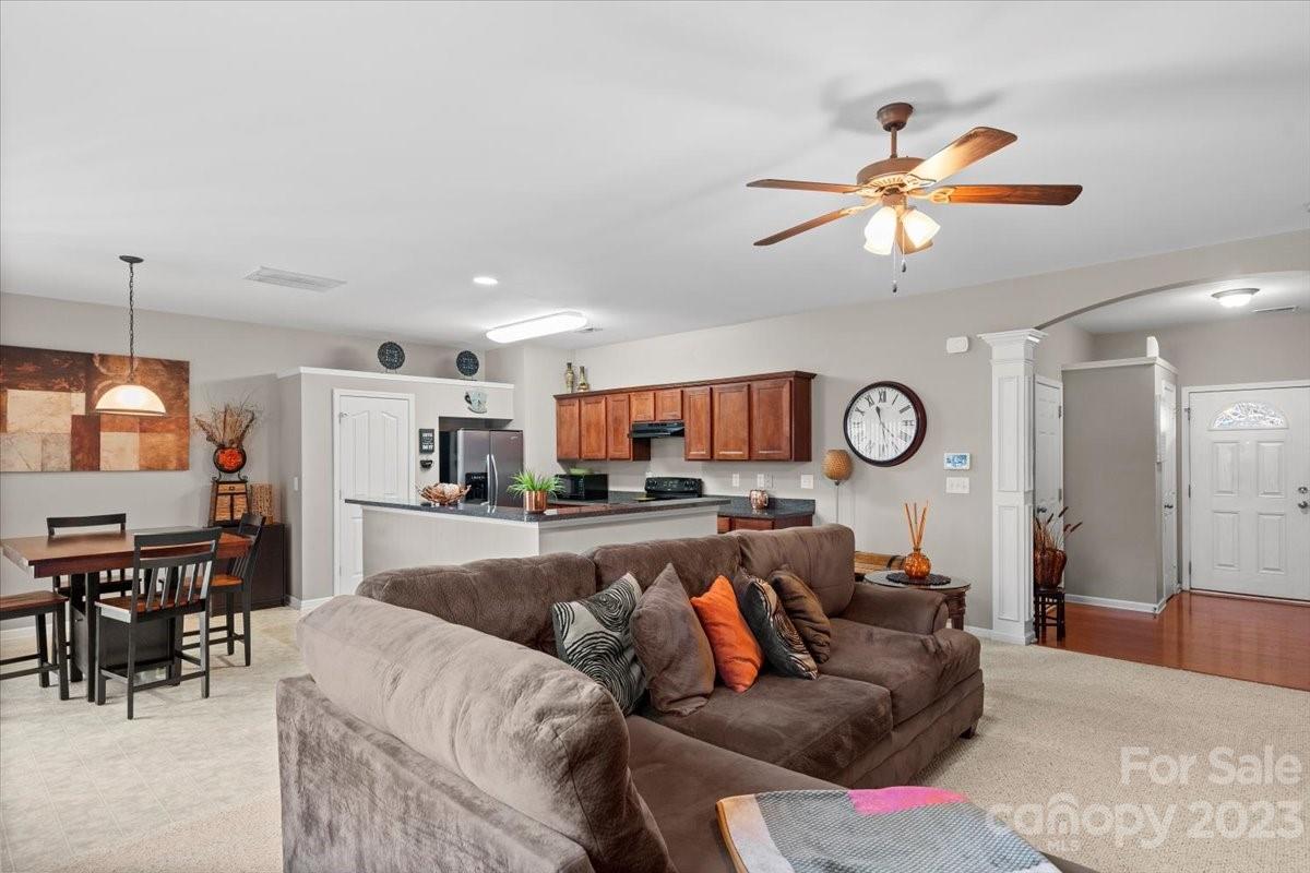 13004 Rothe House Road Charlotte, NC 28273 - Photo 8 of 27 a living room with furniture a kitchen view and a chandelier