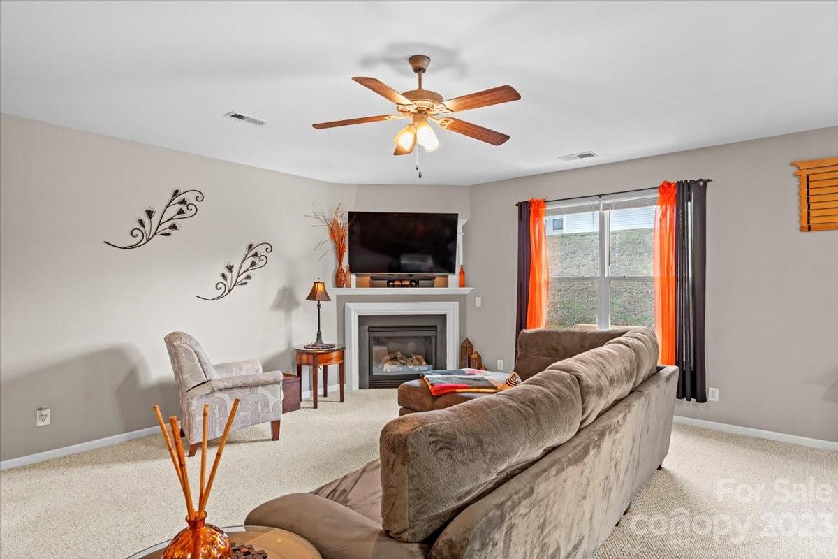 13004 Rothe House Road Charlotte, NC 28273 - Photo 9 of 27 a living room with furniture a fireplace and a flat screen tv