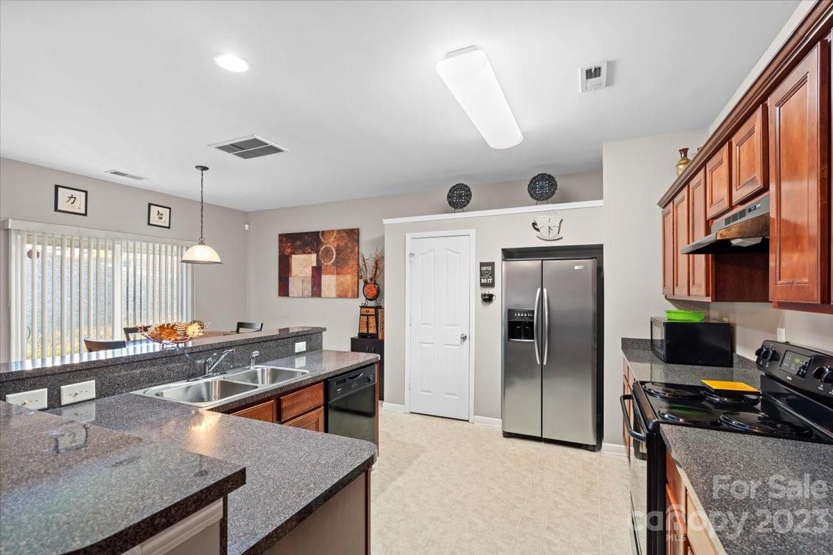13004 Rothe House Road Charlotte, NC 28273 - Photo 10 of 27 a kitchen with stainless steel appliances granite countertop a sink a stove and a refrigerator