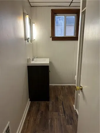 a view of a hallway with wooden floor and a sink