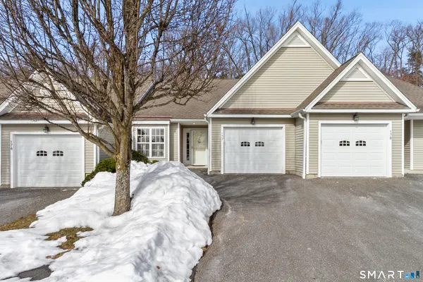 a view of a house with a yard and large tree